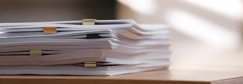 A stack of administrative files on a desk